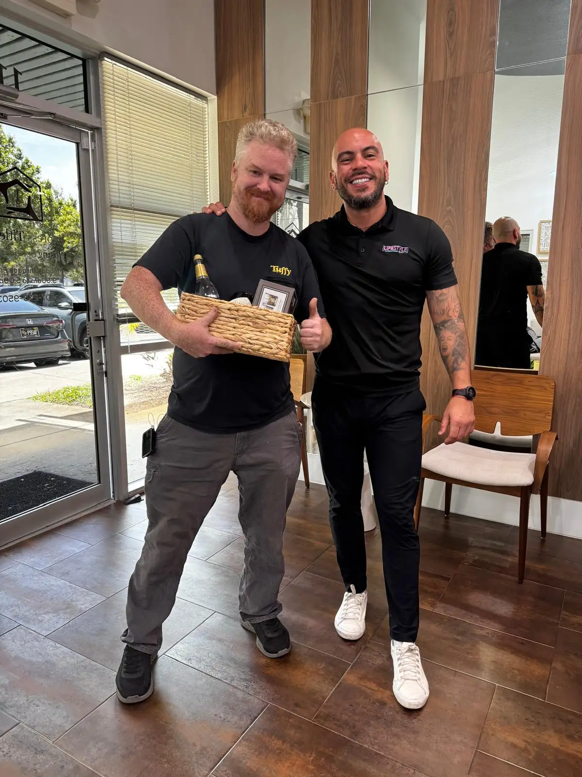 A client giving a thumbs-up with a closing gift basket next to Jose